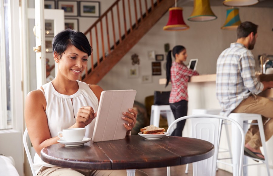 woman reading from tablet in cafe