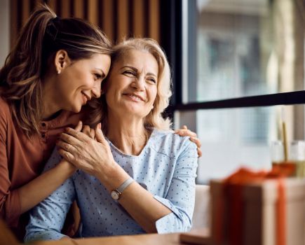 mother's day gifting concept, woman and mother embrace over gift