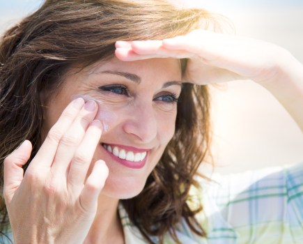 woman applying suncream summer skincare
