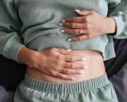 gut health concept woman with hands on tummy
