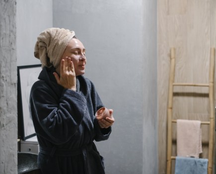 woman applying face cream, morning and evening wellness rituals routine concept