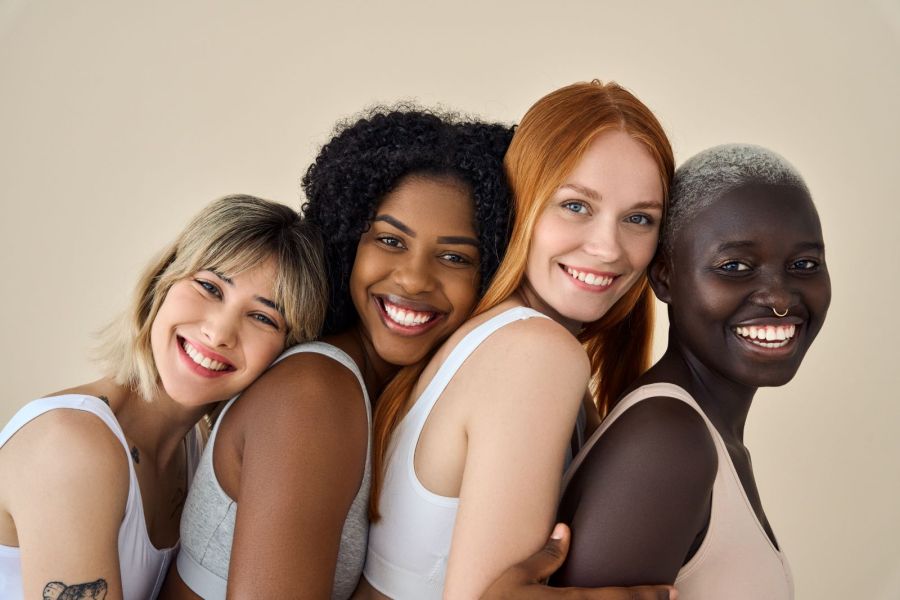 group of diverse women smiling and hugging together