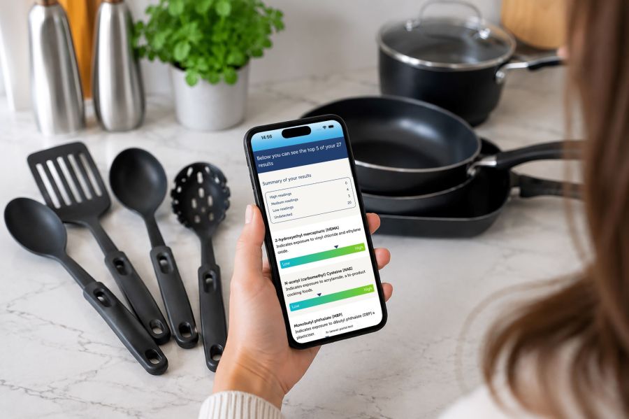 lastinghealth everyday chemicals test results displayed on phone held in front of pots, pans and plastic utensils