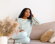 woman sitting on the sofa looking thoughtful