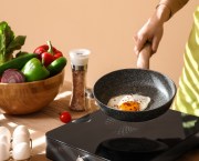 Woman cooking an egg in a pan