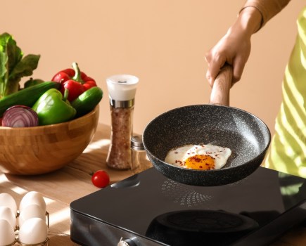 Woman cooking an egg in a pan