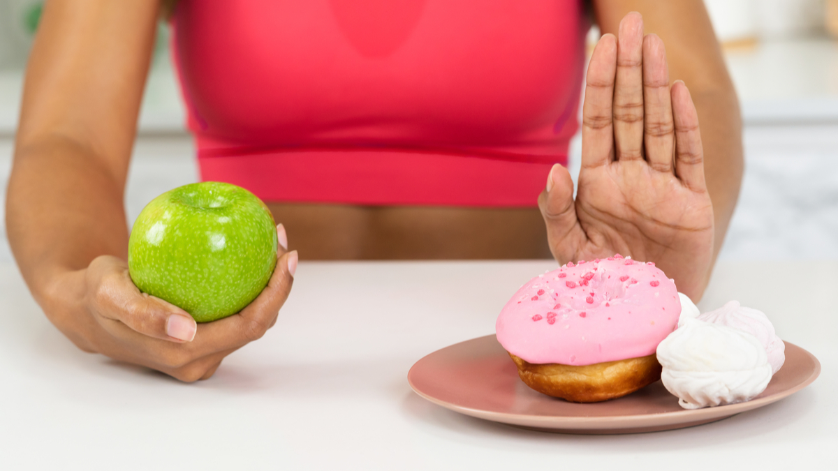 woman with apple and cakes says no to the cakes!