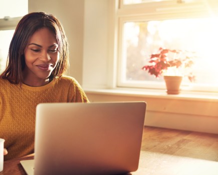 Black woman at computer. Black people are more at risk of diabetes than caucasians